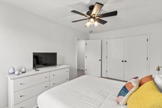 bedroom with a textured ceiling, ceiling fan, and a closet