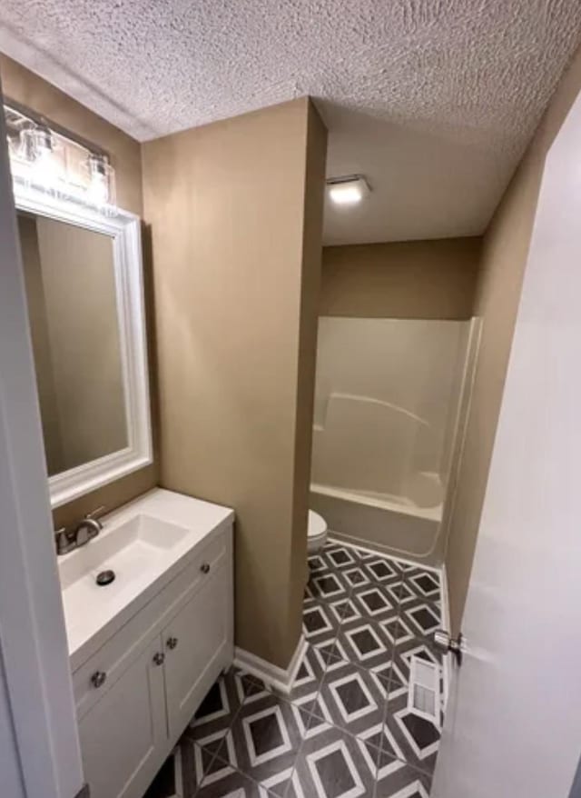 full bath with toilet, tile patterned floors, a textured ceiling, and vanity