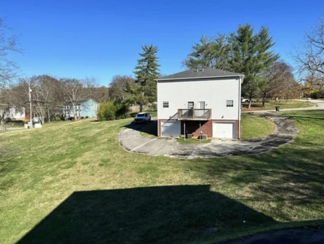 rear view of property with a garage and a lawn