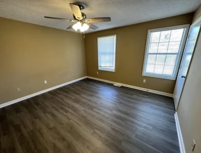 spare room featuring dark wood finished floors and a textured ceiling