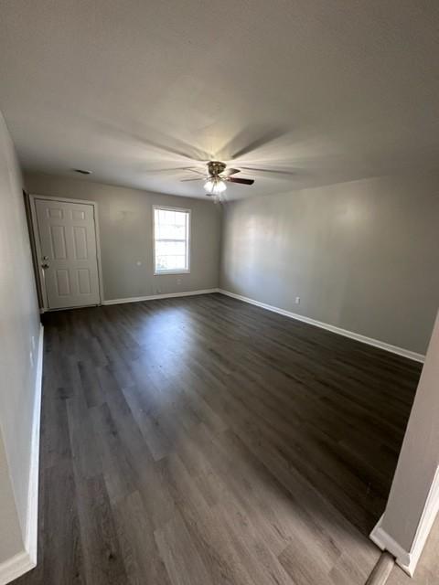 spare room featuring dark wood-style floors, baseboards, and a ceiling fan