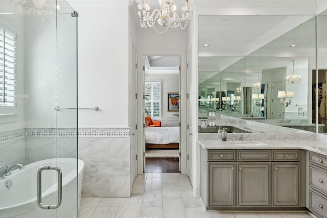 ensuite bathroom featuring connected bathroom, a chandelier, a freestanding bath, ornamental molding, and vanity