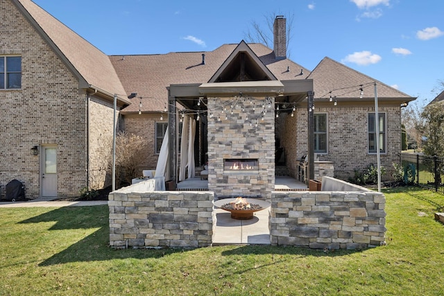 rear view of property with fence, an outdoor stone fireplace, brick siding, a chimney, and a patio area