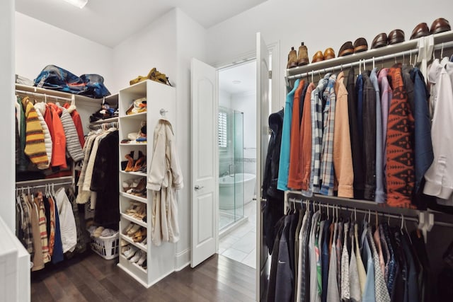 walk in closet with wood finished floors