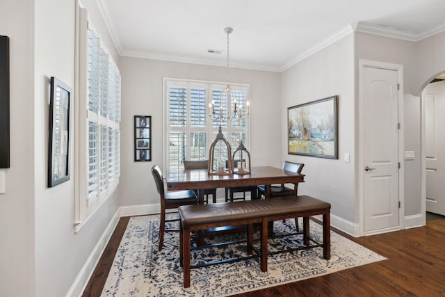 dining space with visible vents, arched walkways, dark wood-type flooring, and ornamental molding