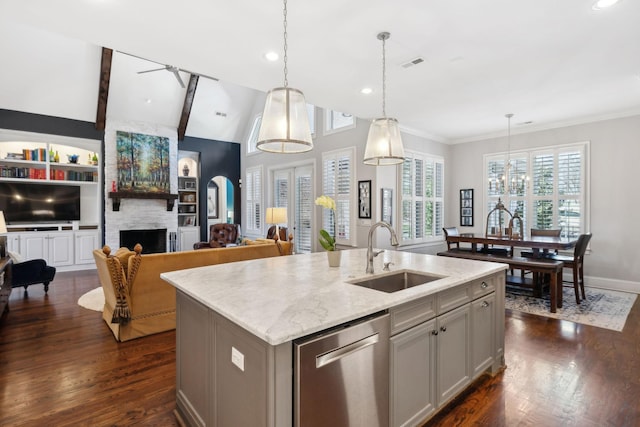 kitchen featuring visible vents, vaulted ceiling with beams, a sink, stainless steel dishwasher, and a large fireplace