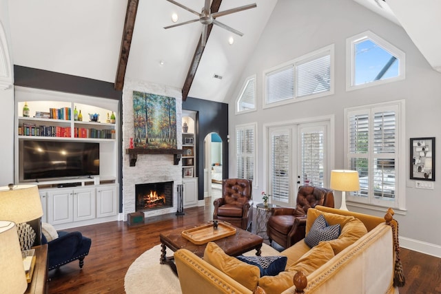 living area with baseboards, a fireplace, arched walkways, ceiling fan, and dark wood-type flooring