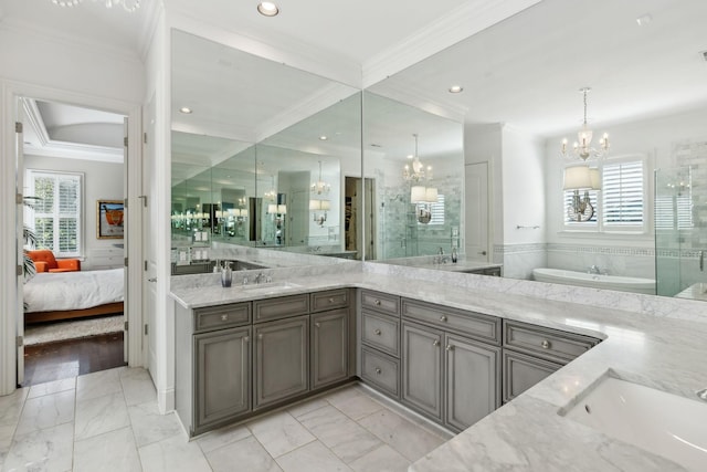 bathroom with a sink, an inviting chandelier, and a wealth of natural light