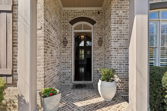 view of exterior entry with brick siding