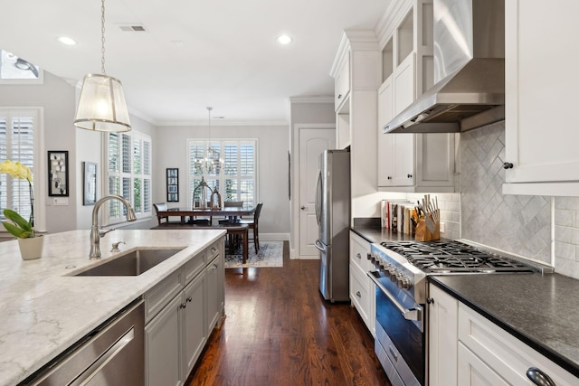 kitchen featuring visible vents, a sink, stainless steel appliances, wall chimney exhaust hood, and crown molding