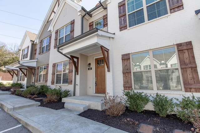 doorway to property featuring brick siding