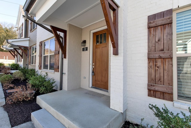 property entrance featuring brick siding