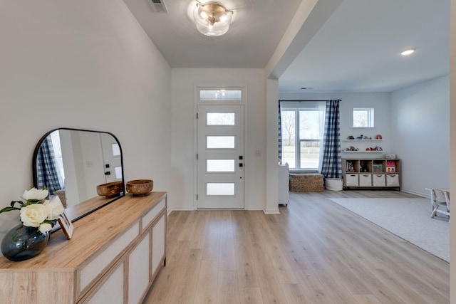 foyer entrance featuring visible vents, light wood-type flooring, and baseboards