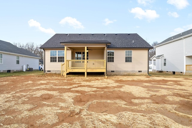 back of house with crawl space, a deck, and roof with shingles