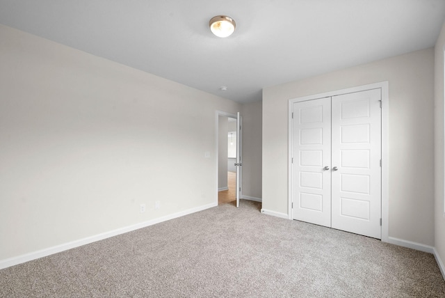 unfurnished bedroom featuring carpet floors, baseboards, and a closet