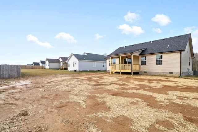 rear view of house with crawl space, fence, and roof with shingles