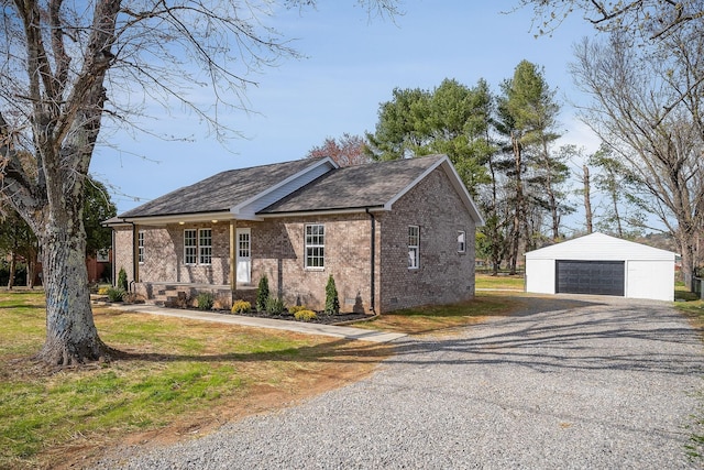 ranch-style home featuring brick siding, a detached garage, a front lawn, an outdoor structure, and crawl space