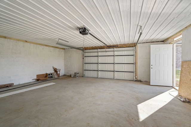 garage with concrete block wall and a garage door opener