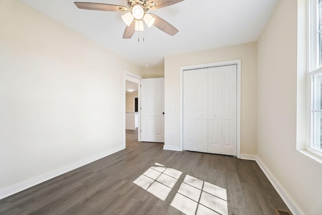 unfurnished bedroom with a ceiling fan, wood finished floors, baseboards, and a closet
