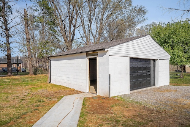 detached garage with fence and driveway