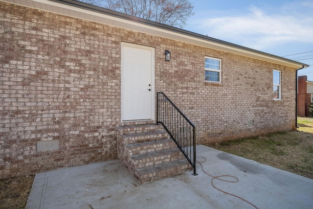 doorway to property with a patio and brick siding