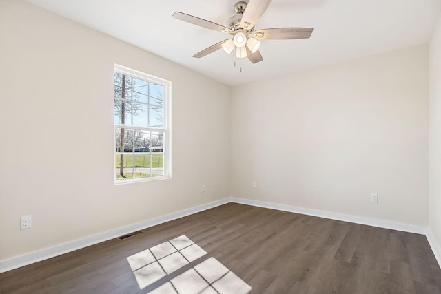 unfurnished room with baseboards, visible vents, and dark wood-style flooring