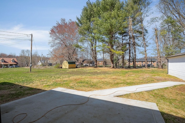 view of yard featuring an outdoor structure, a storage unit, and a patio area