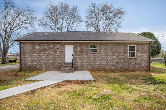 rear view of property featuring a patio, brick siding, and crawl space