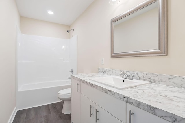 bathroom featuring vanity, shower / bathing tub combination, toilet, and wood finished floors