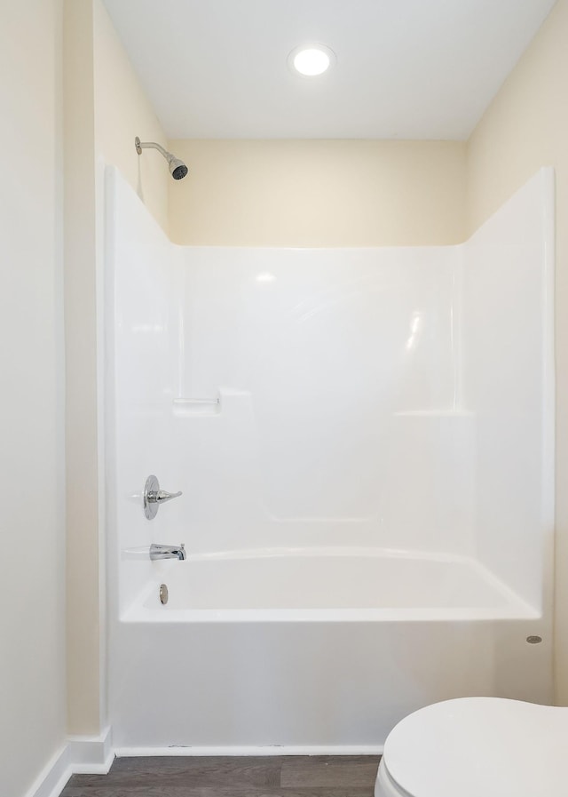 full bath featuring toilet, wood finished floors, and shower / bathtub combination