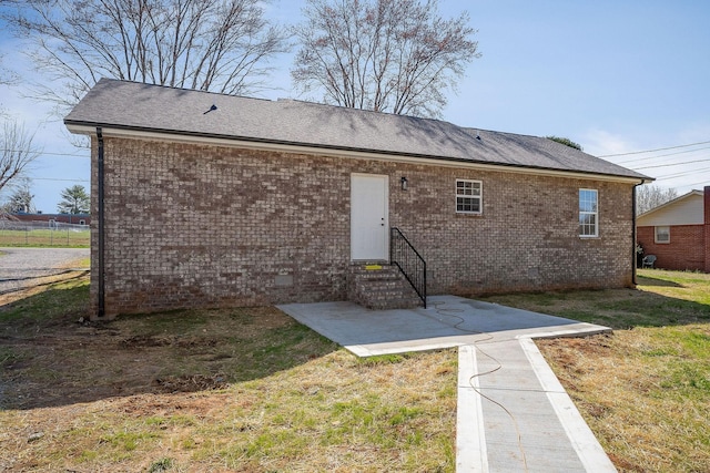back of property with a patio, a yard, and brick siding