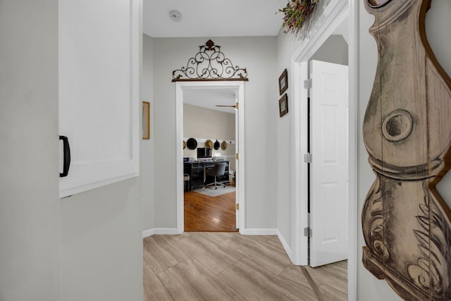 hall featuring wood tiled floor and baseboards