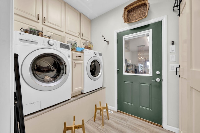 washroom featuring light wood-type flooring, cabinet space, baseboards, and separate washer and dryer