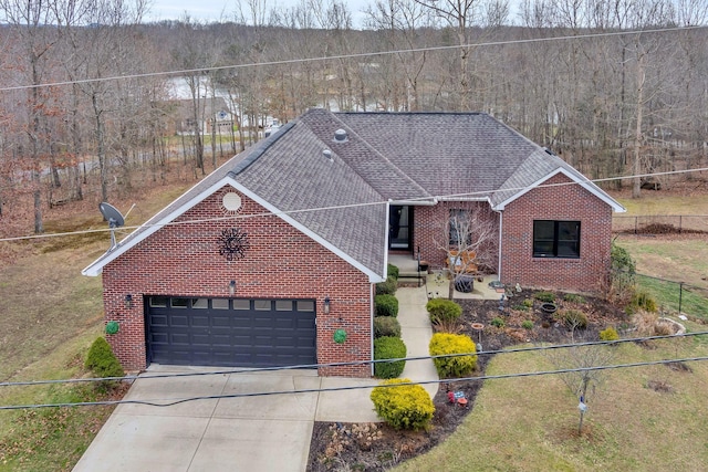 view of front of home with driveway, a shingled roof, an attached garage, fence, and brick siding