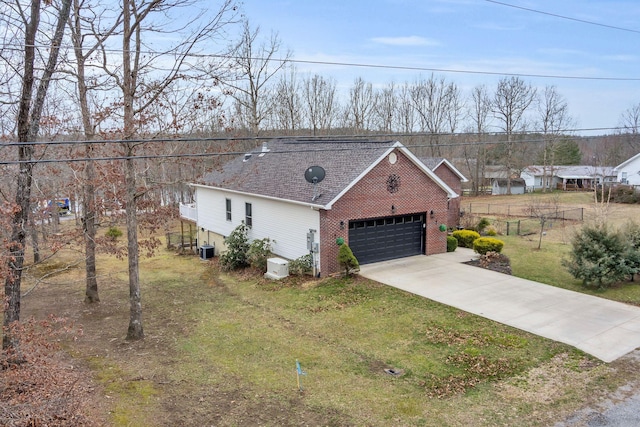 view of front facade with central AC unit, an attached garage, brick siding, driveway, and a front yard