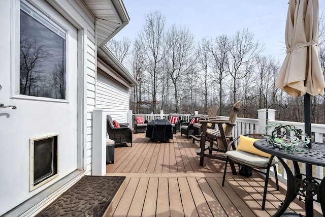 wooden terrace with an outdoor hangout area and outdoor dining area