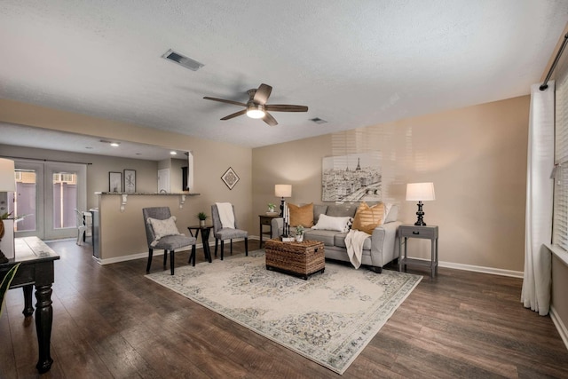 living area featuring dark wood-style floors, visible vents, and baseboards