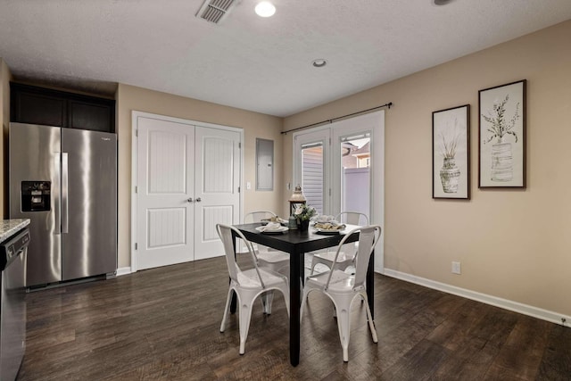 dining space featuring dark wood-style floors, visible vents, a textured ceiling, electric panel, and baseboards