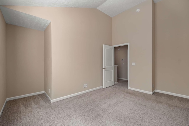 interior space featuring carpet floors, baseboards, vaulted ceiling, and a textured ceiling