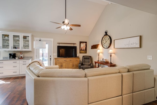 living area with dark wood-type flooring, a ceiling fan, and vaulted ceiling