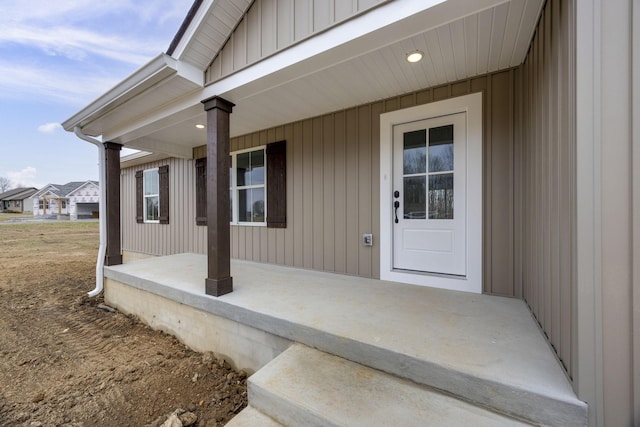 view of exterior entry featuring covered porch and board and batten siding