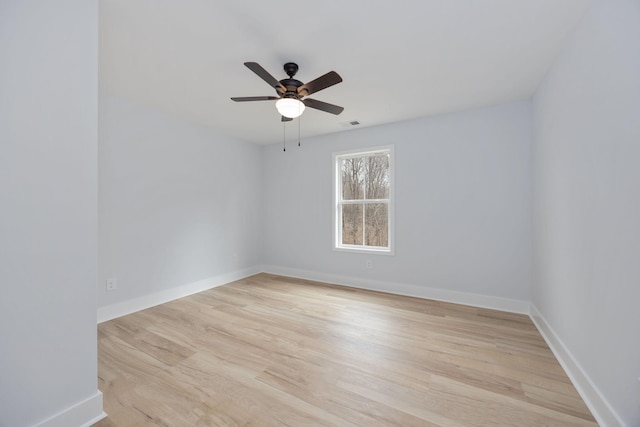 unfurnished room with a ceiling fan, light wood-style flooring, and baseboards