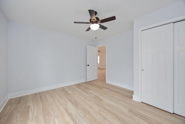 unfurnished bedroom featuring light wood-type flooring, a ceiling fan, baseboards, and a closet