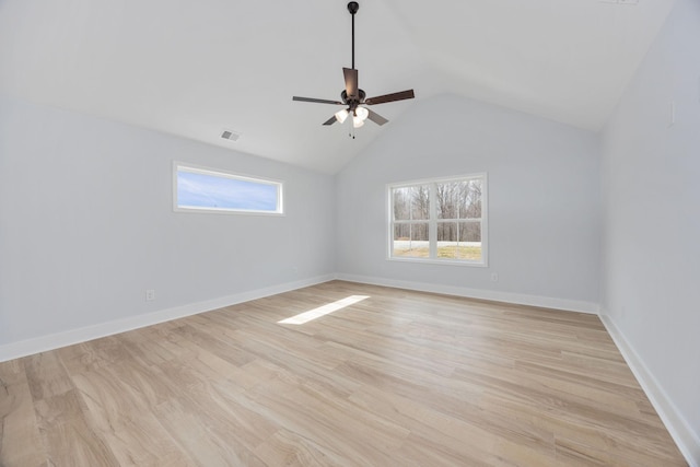 spare room featuring light wood-type flooring, plenty of natural light, and baseboards