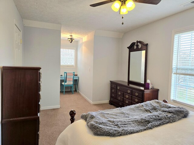 carpeted bedroom with a textured ceiling, multiple windows, visible vents, and baseboards