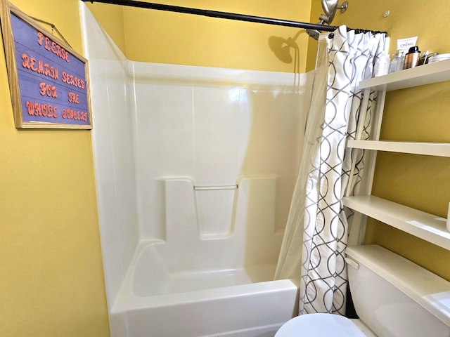 bathroom featuring shower / tub combo and toilet