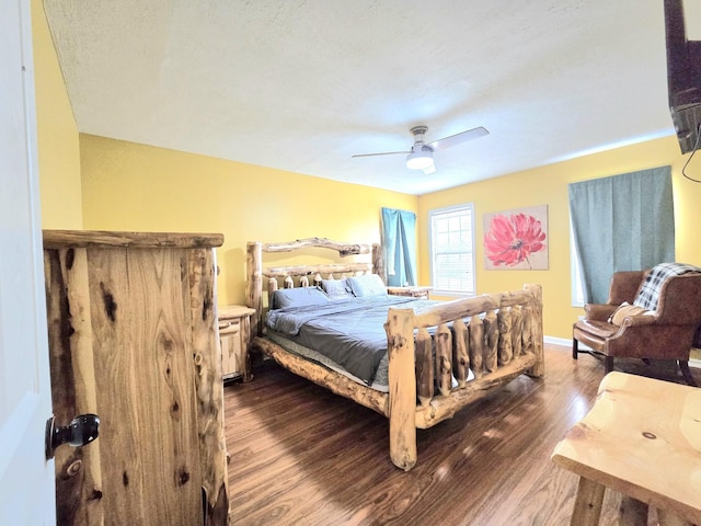 bedroom with dark wood finished floors, a ceiling fan, and baseboards