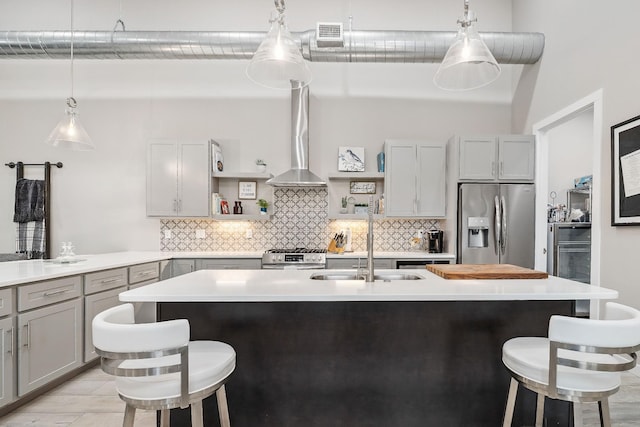 kitchen with stainless steel appliances, a breakfast bar area, gray cabinets, and open shelves