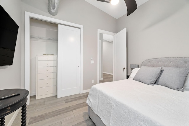 bedroom with light wood-style flooring, baseboards, ceiling fan, and a closet