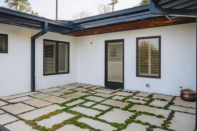 rear view of property with a patio and stucco siding